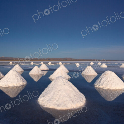 Piles of salt dry in the arid atmosphere of Bolivias Salar de Uyuni.